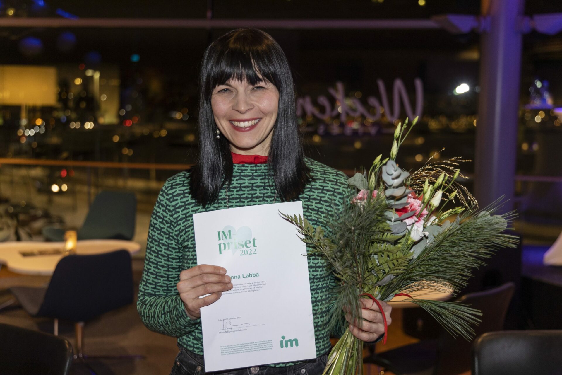 Elin Anna Labba med blommor och diplom.